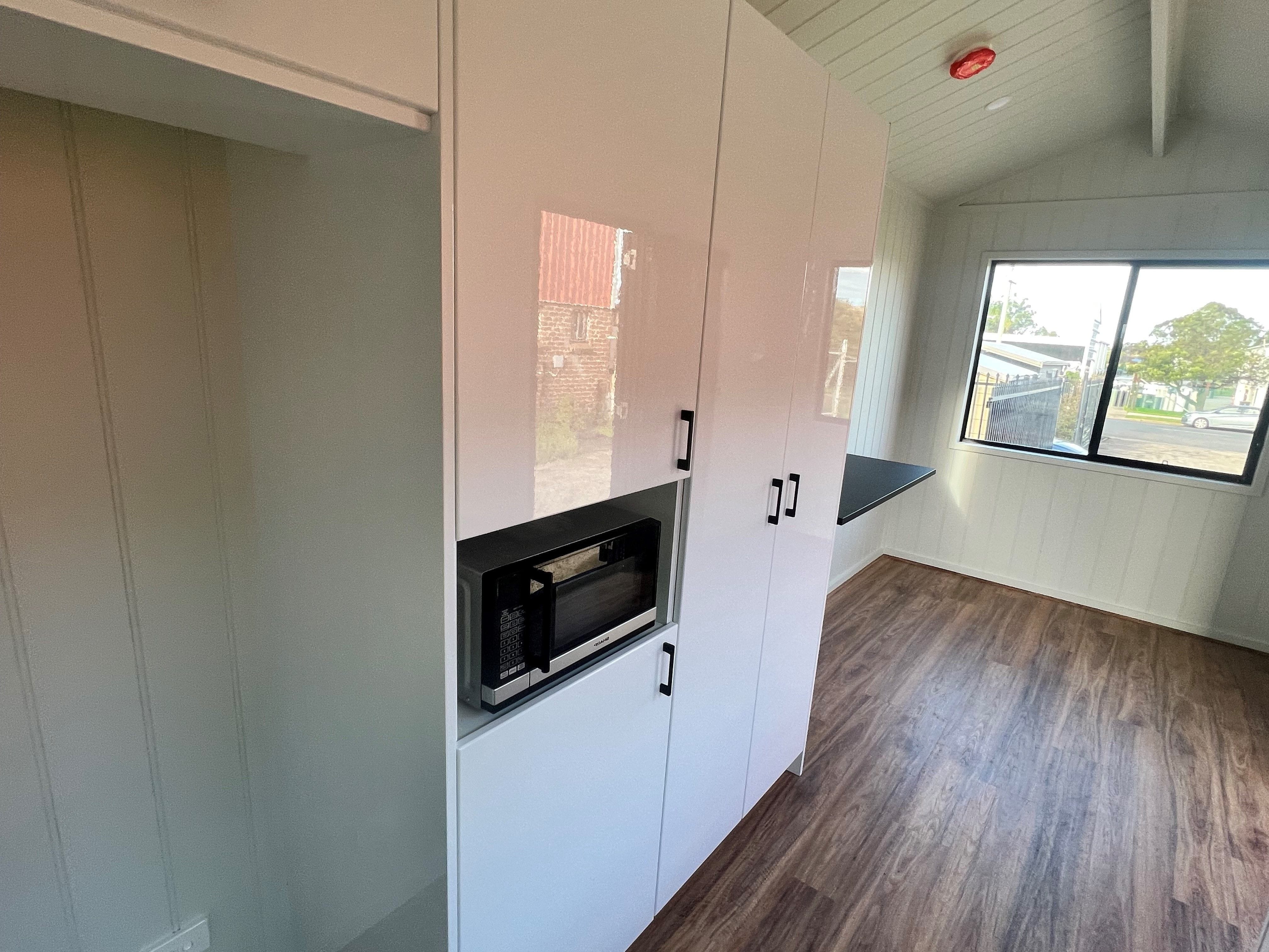 Finished view of the tiny haven tiny house on wheels interior showing the  compact kitchen.