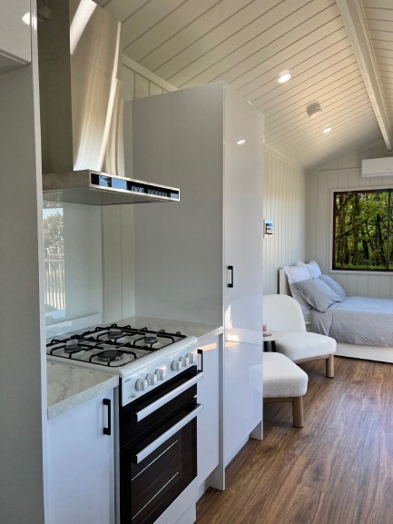 Interior view of The Tiny Voyager  tiny house on wheels, stylish kitchen and  cosy living area.