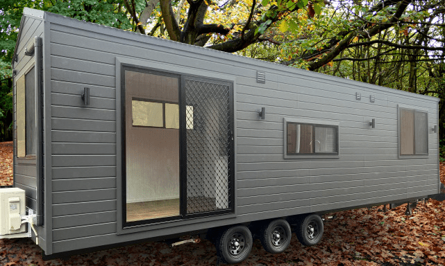 Exterior view of the Tiny Grandeur tiny house on wheels, in a beautiful setting.