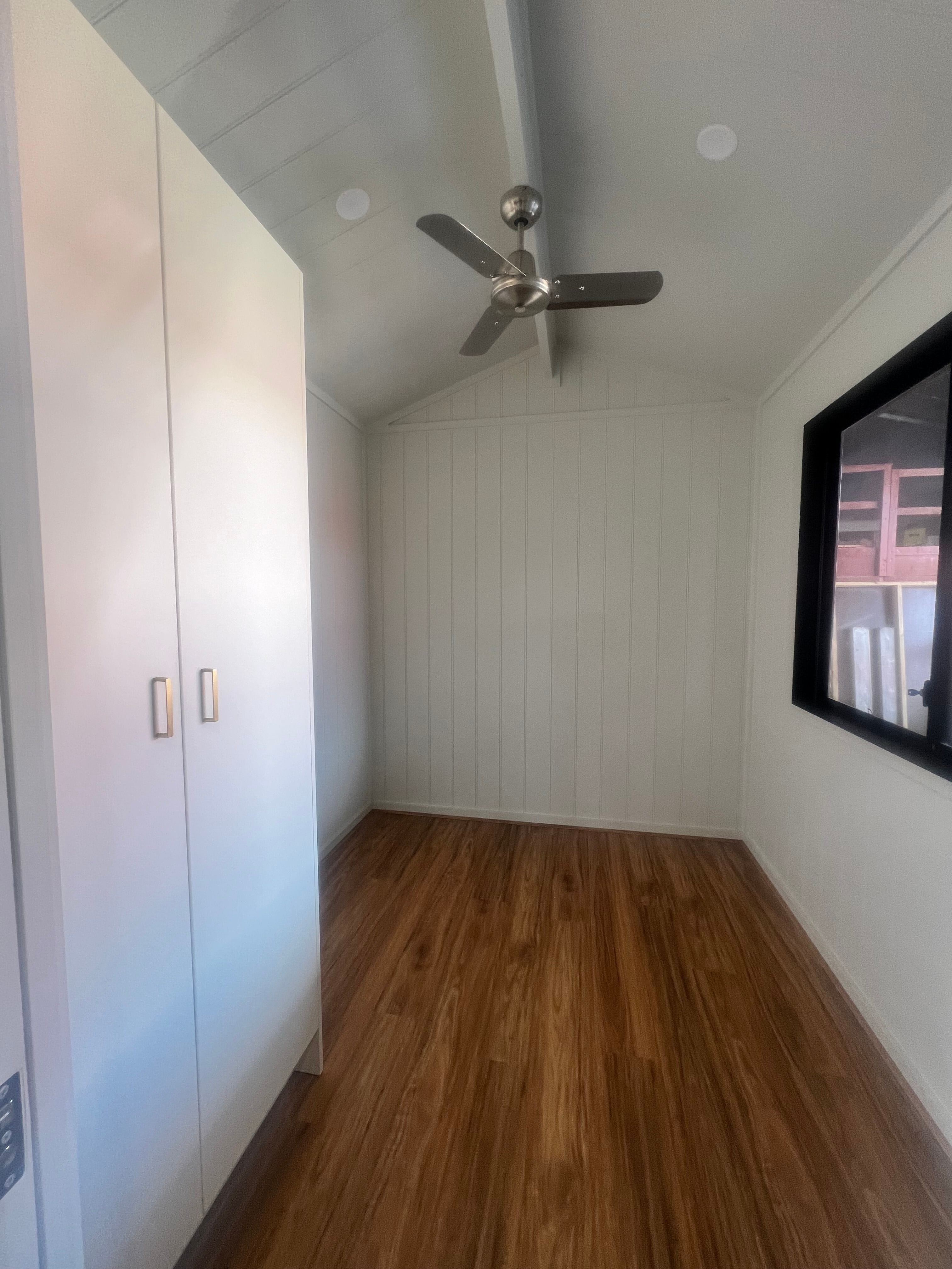 Bedroom view of the Tiny Grandeur tiny house on wheels showing the large wardrobe